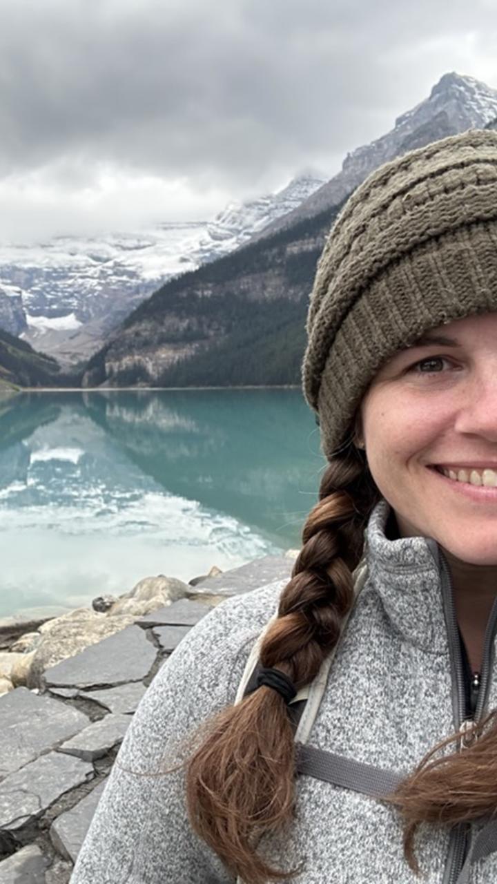 Melanie adventuring outdoors on the water at the base of the mountains