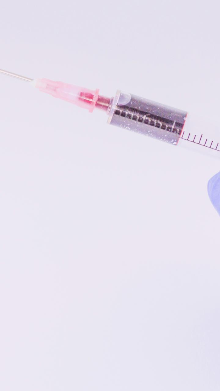 gloved hand holding syringe