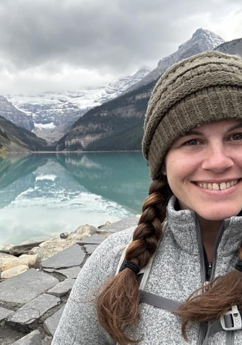 Melanie adventuring outdoors on the water at the base of the mountains