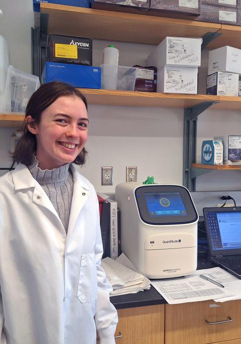 Woman standing in lab next to equipment