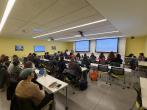 people at tables watching presentaiton on screen