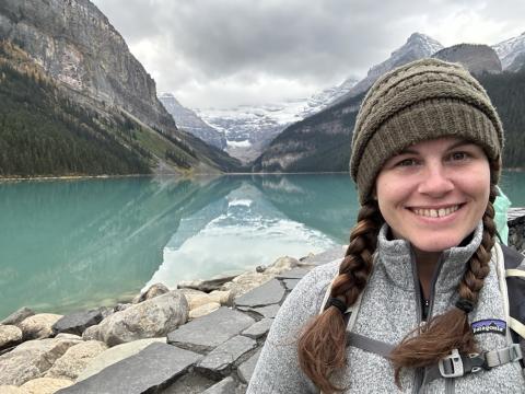Melanie adventuring outdoors on the water at the base of the mountains