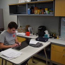David working on research forms at his desk