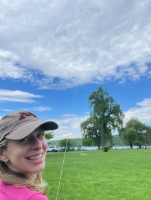 Sarah flying a kite on a cloudy day
