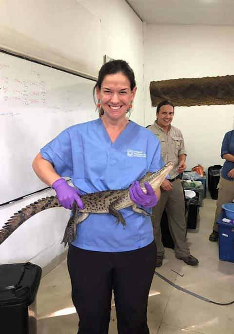 Jenny in scrubs holding a reptile