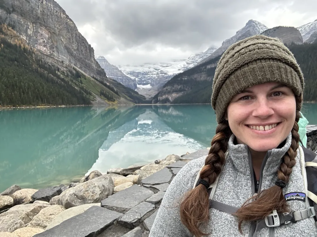 Melanie adventuring outdoors on the water at the base of the mountains