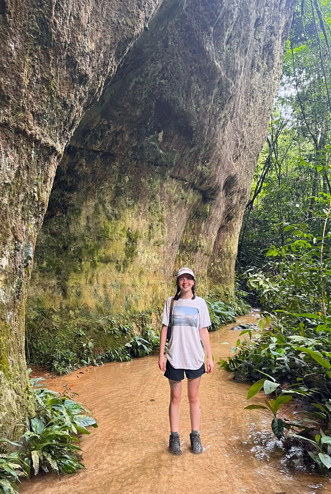 woman standing in water at rock face