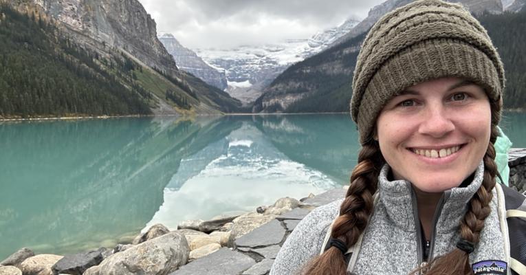 Melanie adventuring outdoors on the water at the base of the mountains