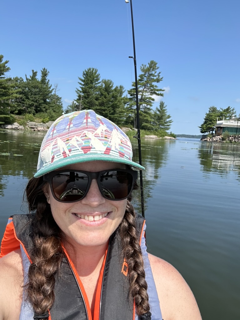 Melanie enjoying the outdoors, fishing on the water