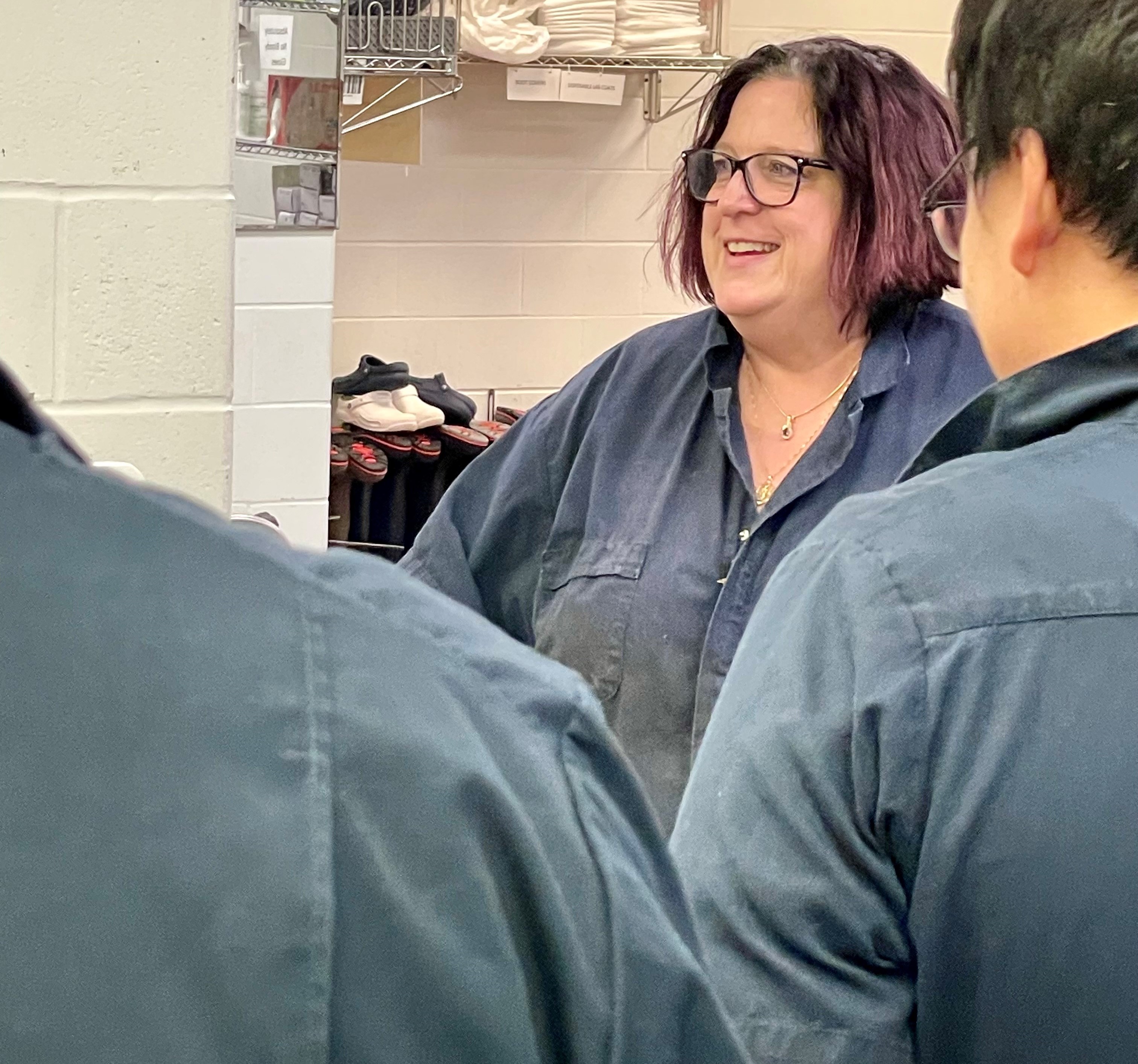 beth with students in blue coveralls